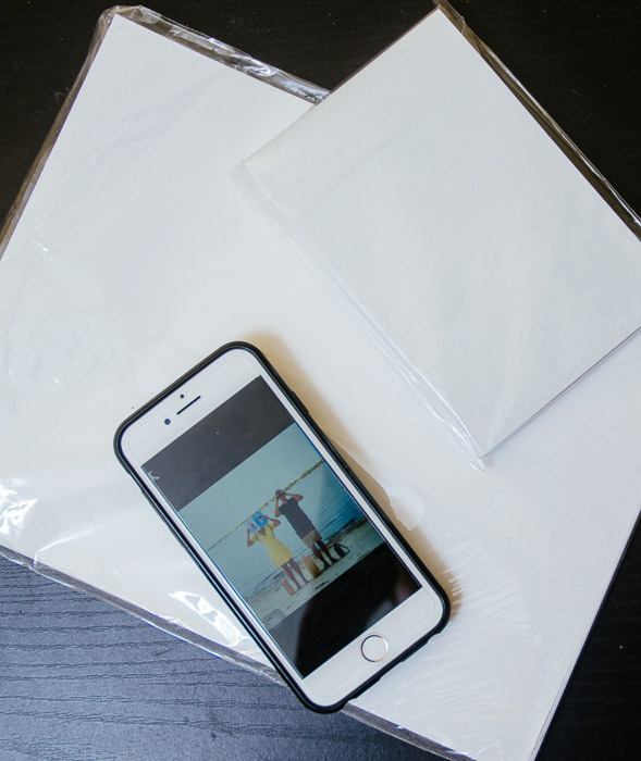 A flat lay photo of an iphone resting on photo paper - print iPhone photos