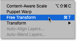 Selecting the Free Transform command from under the Edit menu. Image © 2016 Photoshop Essentials.com