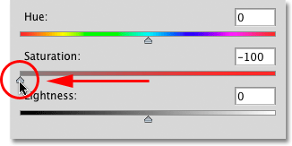 Dragging the Saturation slider to the left in the Hue/Saturation dialog box. Image © 2010 Photoshop Essentials.com